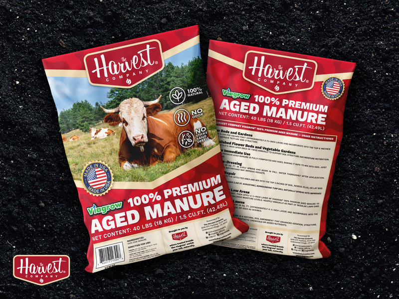 Two packages of Harvest Company aged manure on a dark background