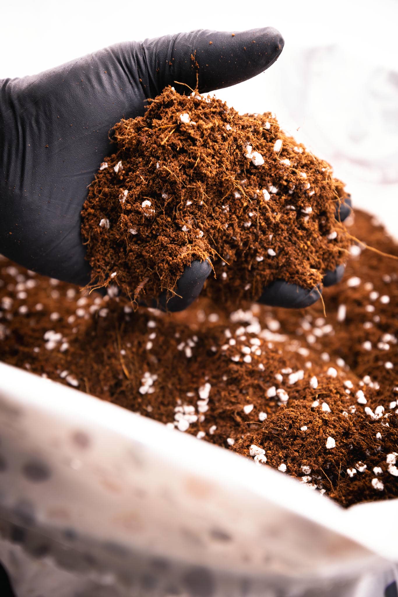 Hand grabbing Coco Coir from bag