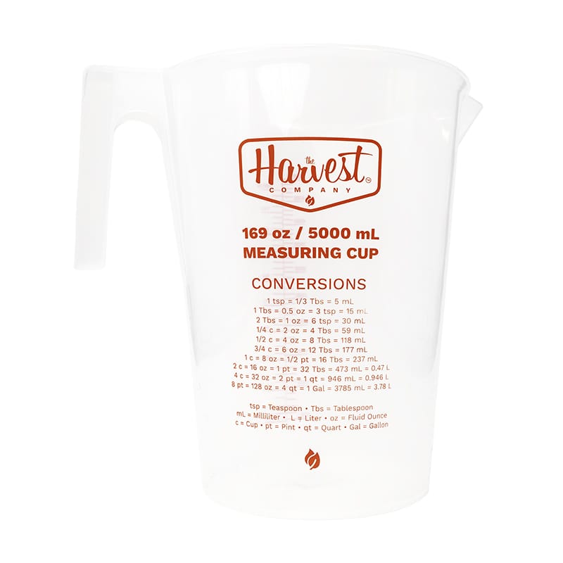 Measuring cup with Harvest Company branding and conversion chart on a white background